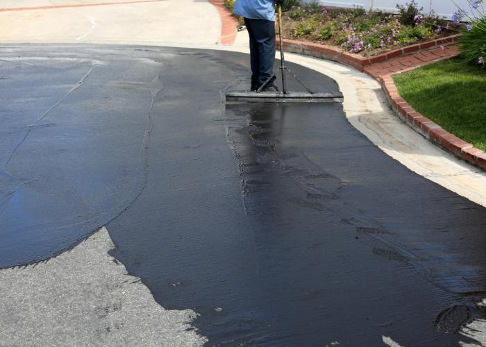 a contractor brushing asphalt for residential paving